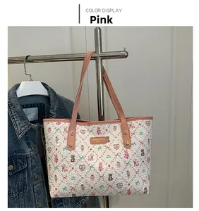 Detailed view of pink quilted tote bag with cute bear patterns and gold rivet hardware