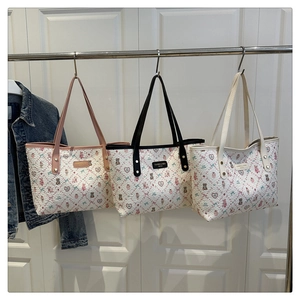 Detailed view of three printed tote bags with cute bear patterns and metal logo tags