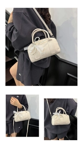 Détail du sac Boston blanc crème avec un nœud en dentelle et une chaîne de perles chic