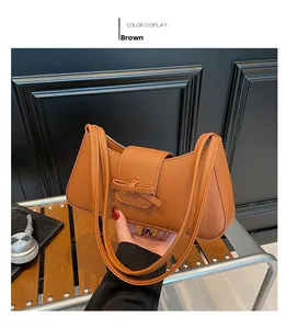 Détail d'un sac porté épaule en cuir marron avec nœud et texture grainée fine