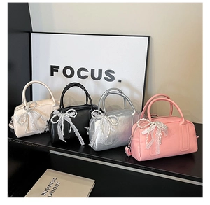 Sacs Boston en quatre couleurs avec nœuds en dentelle et chaînes de perles sur présentoir