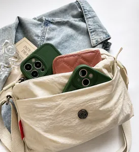 Detail view showing large interior capacity of the beige nylon bag with multiple compartments