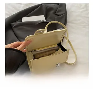 Vue détaillée du petit sac Boston jaune montrant sa capacité avec un portefeuille