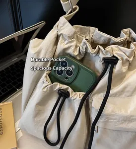 Detail of nylon bucket bag exterior pocket showing large capacity for a smartphone