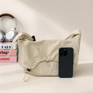 Dettaglio delle dimensioni della grande borsa in nylon accanto a uno smartphone