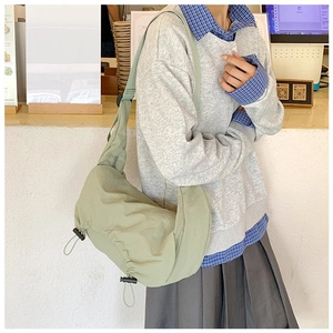 Dettaglio borsa a sacchetto in nylon verde con coulisse e tracolla regolabile larga