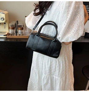 Classic black leather Boston bag with matte texture and adjustable shoulder strap