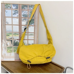 Dettaglio borsa a tracolla in nylon giallo con coulisse regolabili sui lati decorativi