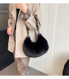 Detail of plush black hobo bag featuring brown wooden beaded strap and soft faux fur texture