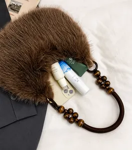 Detail of plush brown tote with wooden beaded handle showing spacious interior storage