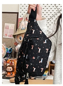 Detailed view of black sling bag with cartoon dog print and adjustable strap