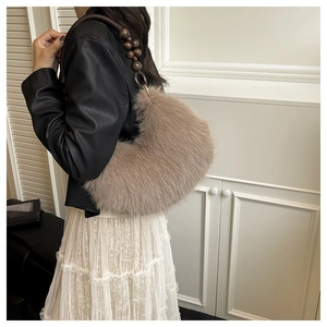 Detailed shot of light brown plush handbag with vintage wooden bead strap and silver rings