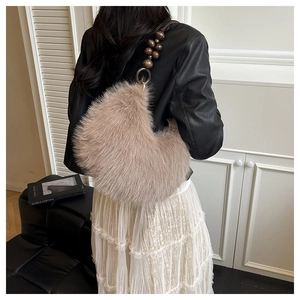 Detail of plush crescent shoulder bag with dark brown beaded strap and soft beige faux fur