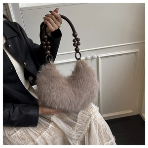 Detail of plush brown shoulder bag featuring chic beaded handles and soft faux fur texture