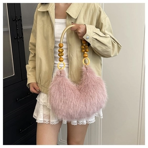 Pink faux fur crescent handbag with unique beaded wooden handle and plush texture detail