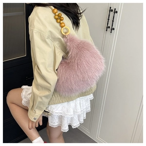Detail of pink faux fur tote bag with large wooden bead handle and golden metal rings