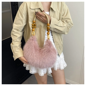 Chic pink faux fur hobo bag with unique wooden beaded handle for autumn style