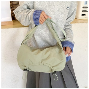 Dettaglio della borsa a tracolla in nylon verde chiaro con coulisse regolabile e tessuto