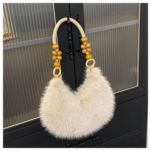 Detail of faux fur beige handbag featuring bohemian wooden bead strap and plush texture