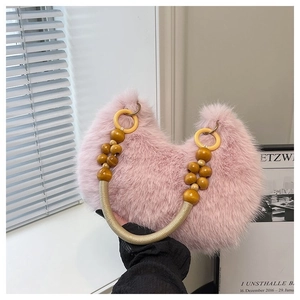 Detailed shot of pink plush faux fur crescent handbag with beaded decorative handle