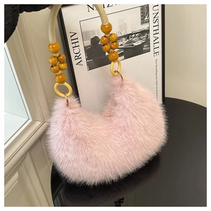 Detailed close-up of pink faux fur crescent bag with orange wooden beads on the handle