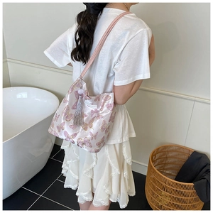 Detail of pink satin tote bag with purple butterfly embroidery and tassel charm