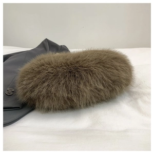 Close-up of the plush faux fur texture on a dark brown fashion handbag with beads