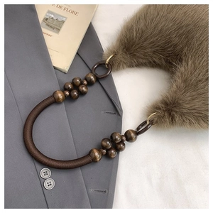 Detail of beaded composite handle on brown faux fur handbag with stylish woven rope