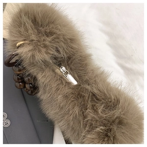 Detailed close-up of soft brown faux fur bag with silver zipper and beaded handle strap