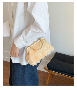 Detalle de bolso bandolera naranja claro con pétalos 3D y elegantes asas doradas