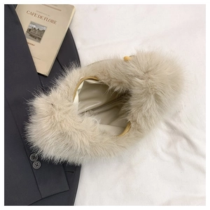 Detail view of plush faux fur bag with golden zipper and beaded handle accent