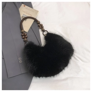 Detail of black faux fur handbag with stylish dark brown wooden bead handle on white background