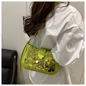 Close-up of bright neon green sequin shoulder bag with shiny metallic texture on model