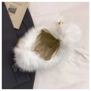 Internal detail of white faux fur handbag featuring cream lining and zipper closure