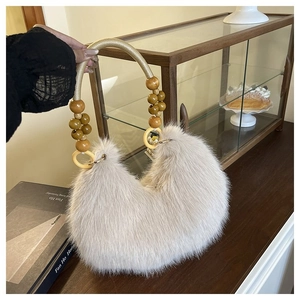 Detail of plush faux fur handbag featuring beaded handle and decorative wooden rings