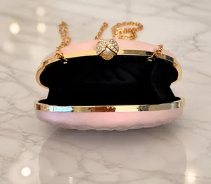 Internal view of pink shell-textured evening clutch with pearl clasp and gold chain
