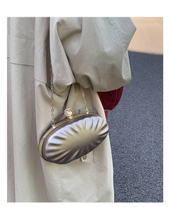 Detail of champagne gold shell clutch bag featuring pleated texture and pearl rhinestone clasp
