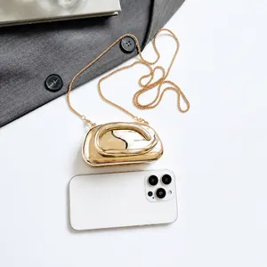 Comparaison détaillée de la taille de la mini pochette dorée par rapport au smartphone