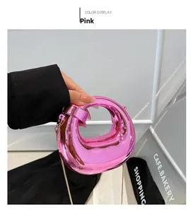 Primer plano del mini bolso rosa metalizado con textura acolchada y cadena dorada