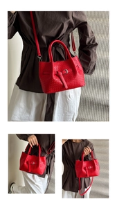 Close-up of red woven bucket bag with top handle and detachable strap in a modern setting