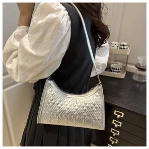 Close-up of a silver quilted baguette bag showing metallic texture and detailed stitching