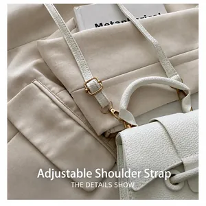 Detail showing adjustable strap with gold metal buckle on white lychee leather bag