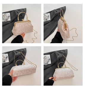 Detail of floral embroidery on beige handbag with gold metal handle and chain strap