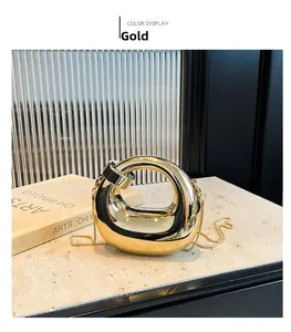 Detalle de bolso de fiesta dorado irregular con acabado de espejo metálico y cadena