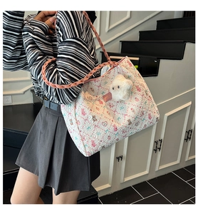 Dettaglio della borsa tote floreale in seersucker con manico rosa e orsetto