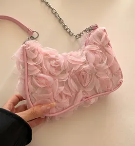 Detail shot of 3D rose petal textures and metallic chain on this pink evening bag