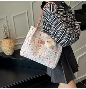 Dettaglio della borsa shopper bianca stampata con manici rosa intrecciati e stella