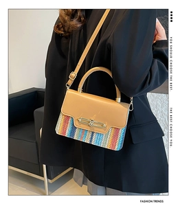 Détail du sac tissé coloré avec rabat en cuir marron et fermoir métallique doré brillant