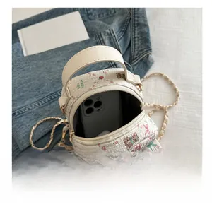 Mini floral bear backpack showing inner storage capacity with a smartphone inside