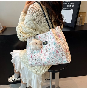 Dettaglio della borsa shopper floreale con manici neri intrecciati e ciondolo a stella